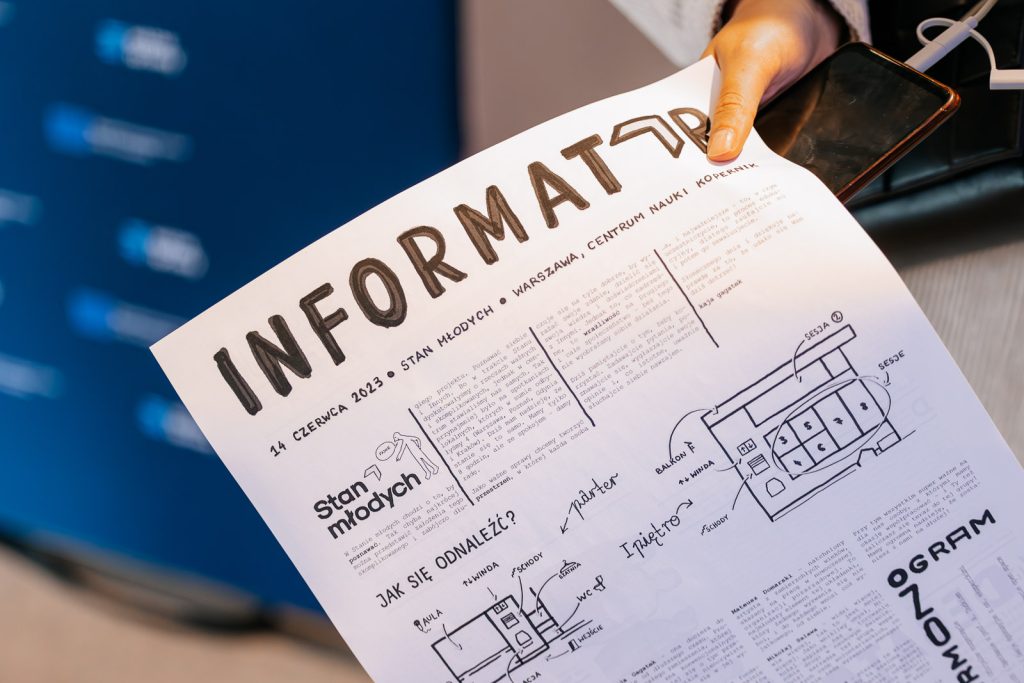 Osoba trzyma informator o wydarzeniu "Stan Młodych" w Centrum Nauki Kopernik, 14 czerwca 2023.