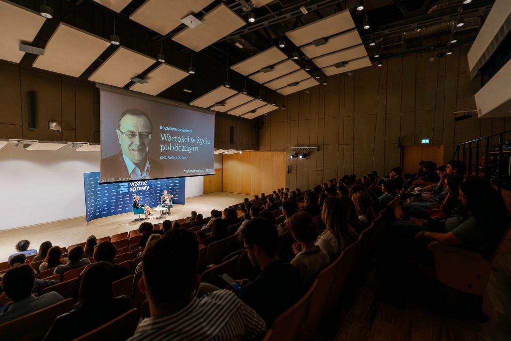 Sala konferencyjna z publicznością, prelegenci przed ekranem "Wartości w życiu publicznym".