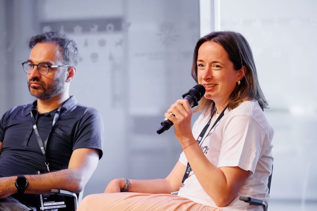 Kobieta mówi do mikrofonu obok mężczyzny w okularach podczas panelu na konferencji Stan Młodych 2025.