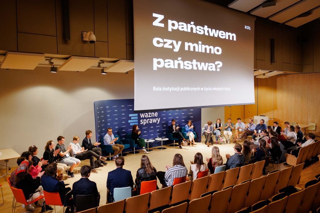 Dyskusja w kręgu pod ekranem z pytaniem „Z państwem czy mimo państwa?” na konferencji Stan Młodych 2025.