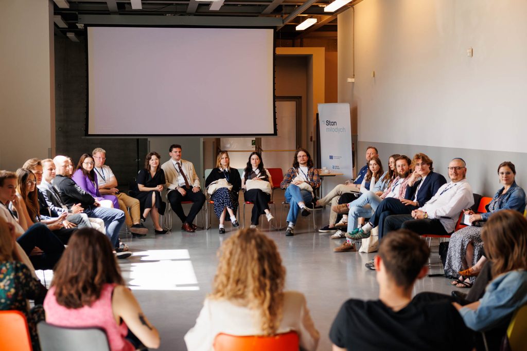 Uczestnicy siedzą w kręgu w sali warsztatowej na konferencji Stan Młodych 2025.