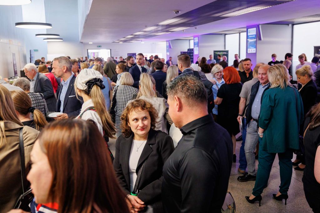 Tłum uczestników rozmawia w holu konferencji Technologie dla Biznesu.