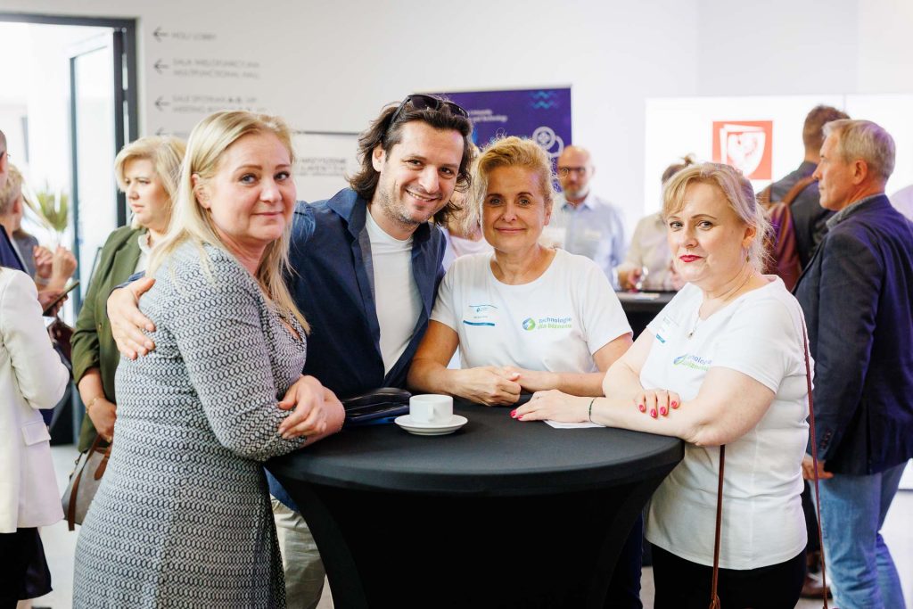 Uczestnicy konferencji Technologie dla Biznesu rozmawiają przy wysokim stoliku.