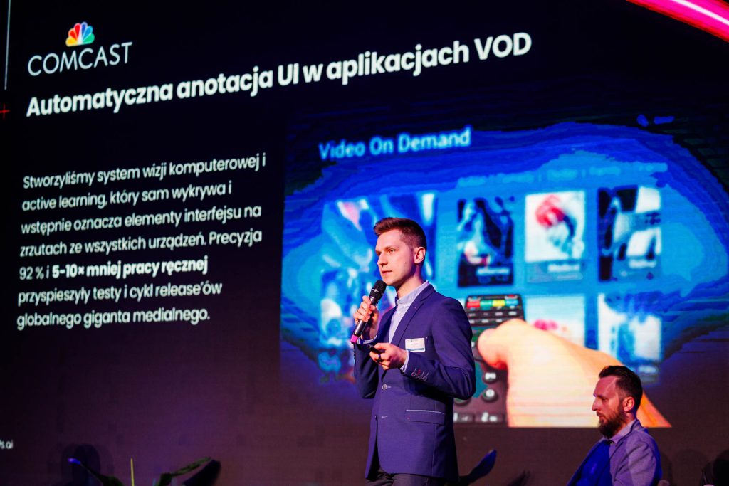 Prelegent przedstawia projekt automatycznej anotacji UI w aplikacjach VOD dla Comcastu na Technologie dla Biznesu.