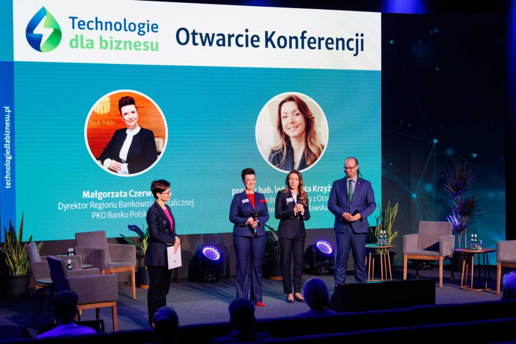 Otwarcie konferencji Technologie dla Biznesu – prowadzący i goście na scenie przed dużym ekranem.