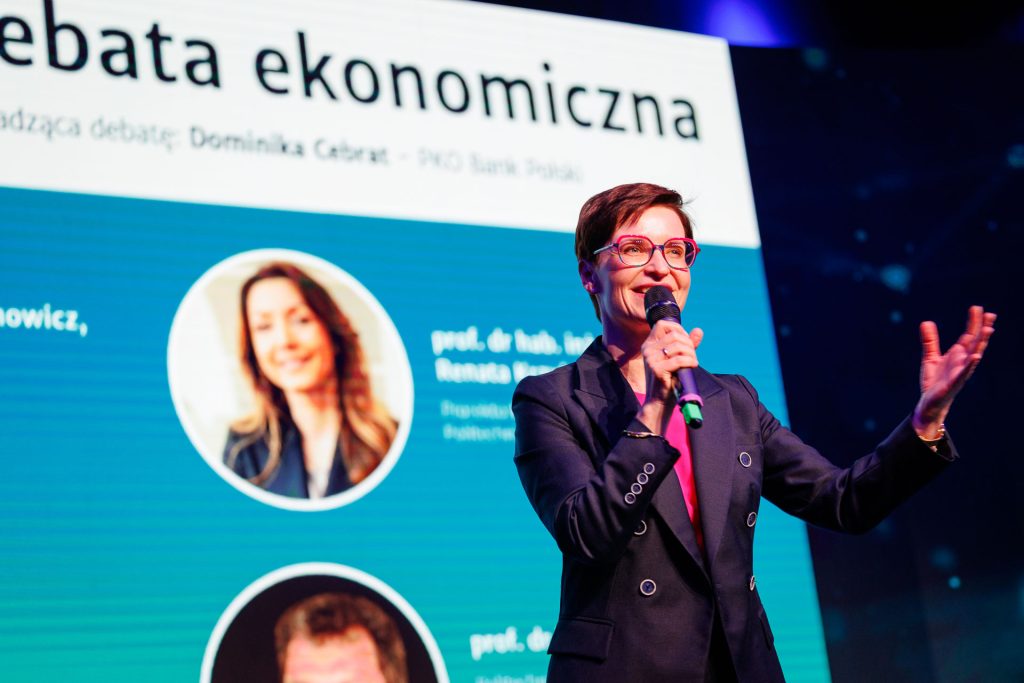 Prowadząca zapowiada debatę ekonomiczną na scenie Technologie dla Biznesu.
