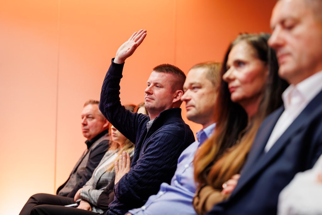 Uczestnik podnosi rękę, by zadać pytanie podczas konferencji Technologie dla Biznesu.