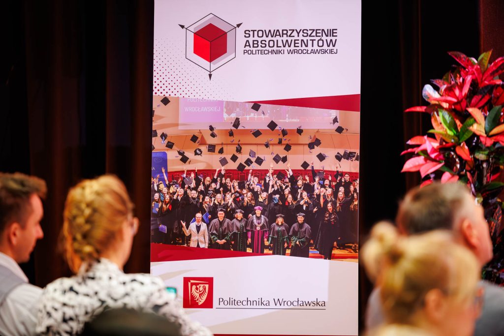Roll-up Stowarzyszenia Absolwentów Politechniki Wrocławskiej na sali konferencyjnej.