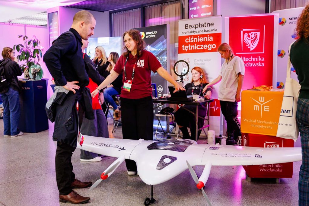 Dron na stoisku Politechniki Wrocławskiej, wokół rozmawiający uczestnicy Made in Wrocław 2025.