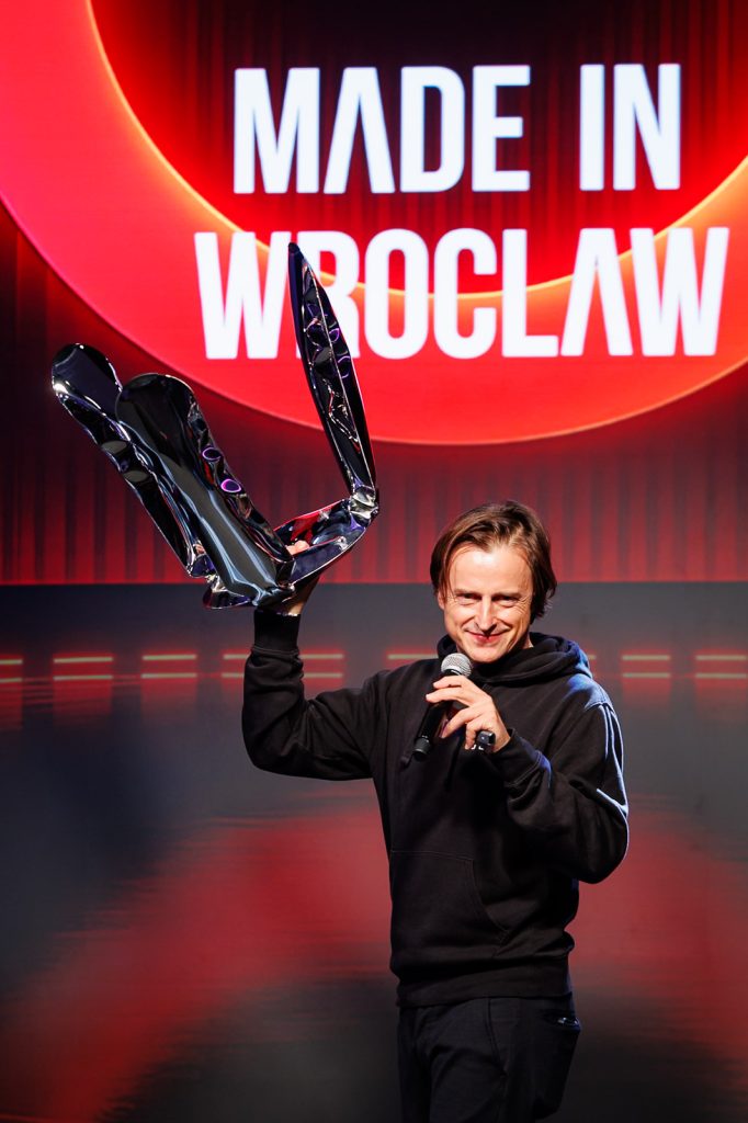 Oskar Zięta unosi przedmiot z dmuchanej stali na scenie Made in Wrocław 2025.